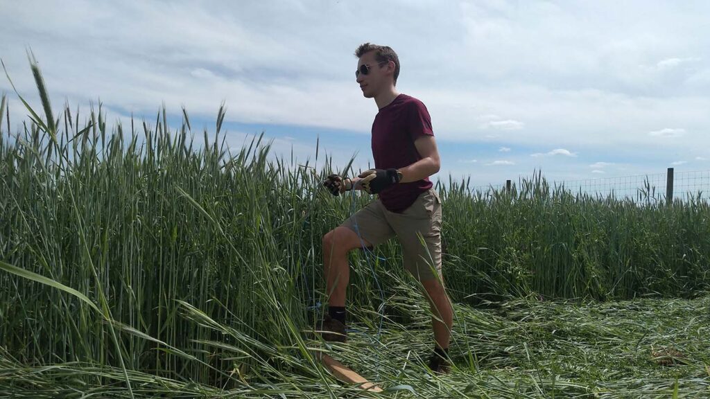 Sam Arnold '22 wears sunglasses and stands beside a field